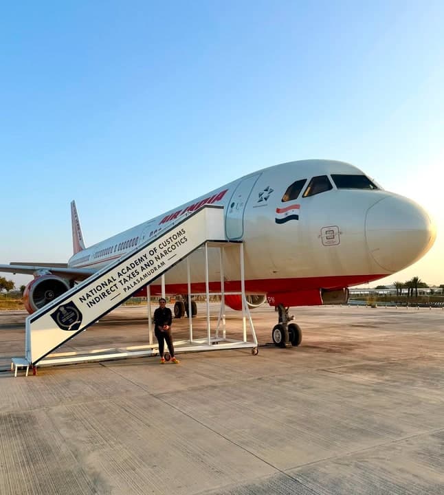 The branded boarding stairs of the NACIN training aircraft at sunset, with a visitor on the steps